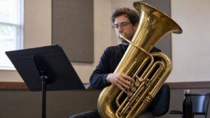 Tuba player practicing range and endurance in a quiet practice room