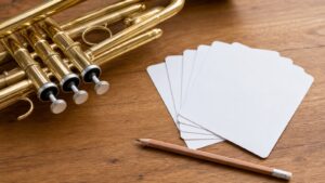 Close-up of trumpet valves beside blank reference cards