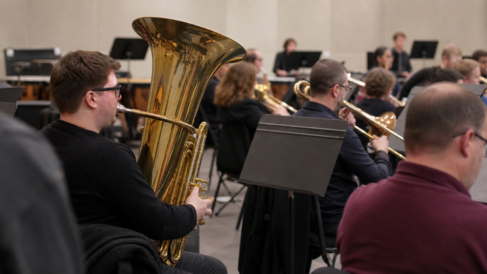 Tuba player anchoring a large ensemble rehearsal